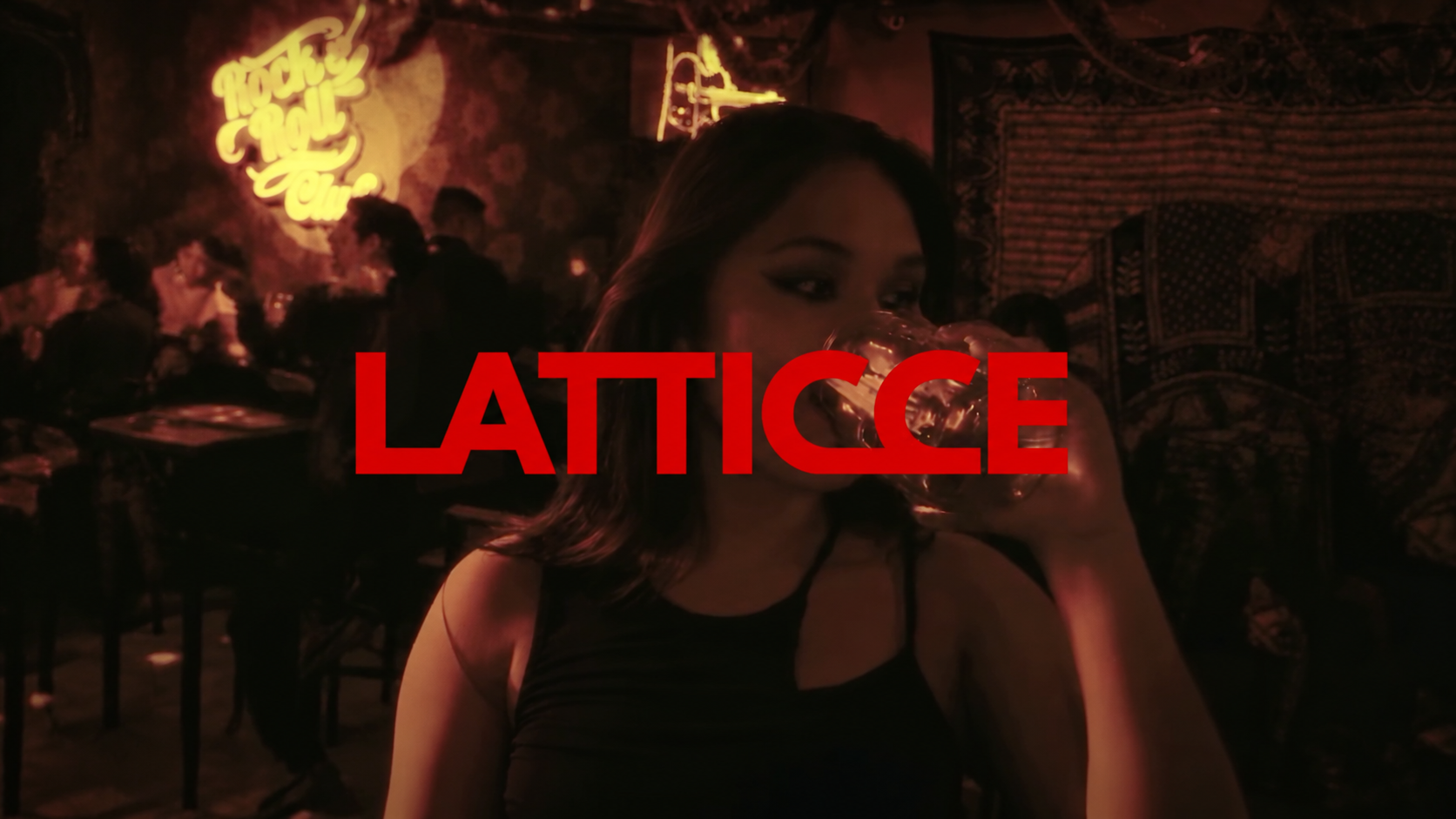 Fotograma de ALEJATE en un bar, con el logotipo rojo de LATTICCE sobre la escena.