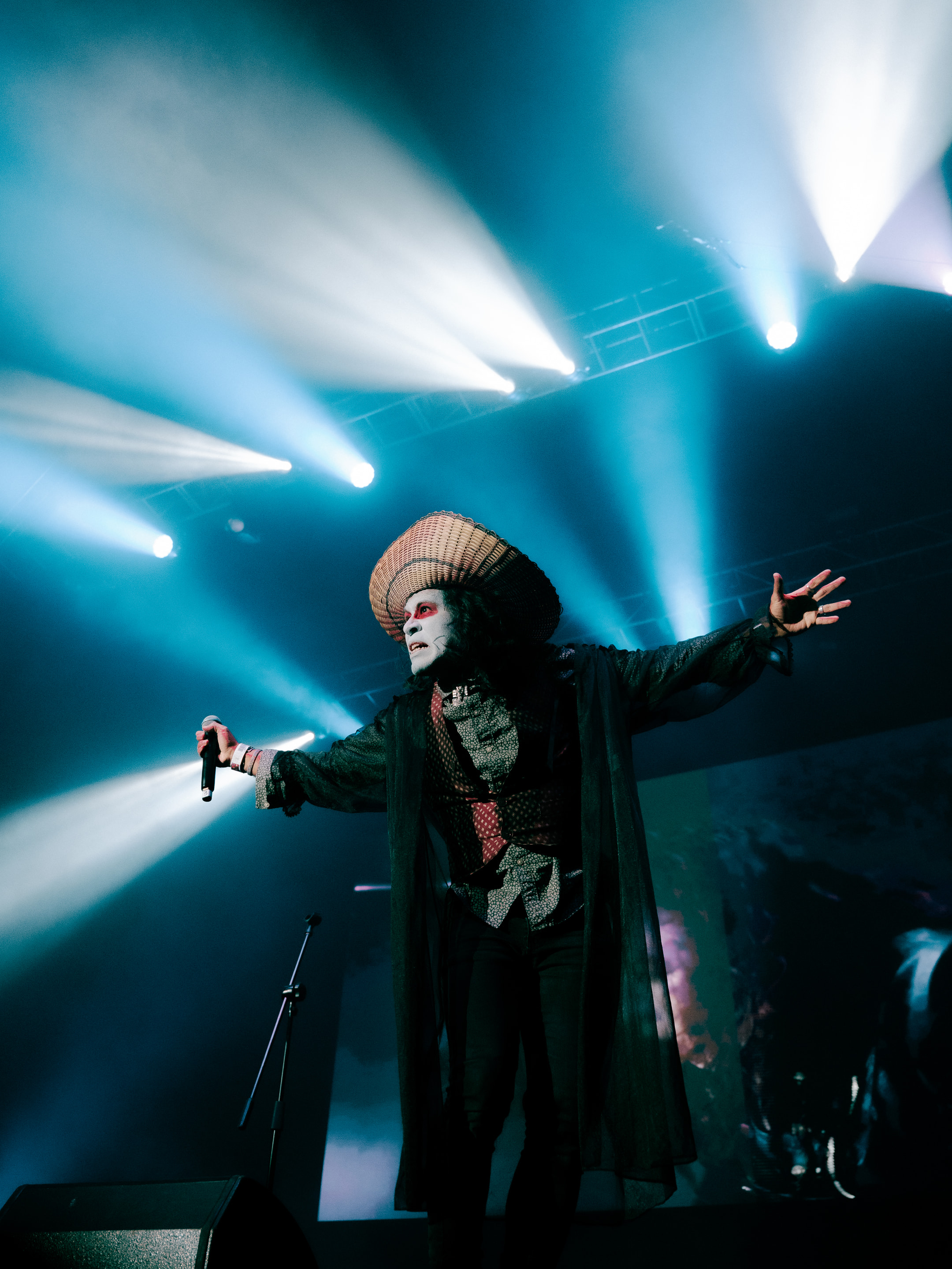 Integrante de La Bande-Son Imaginaire abre los brazos bajo haces de luz cian durante su concierto en el Pepsi Center WTC.